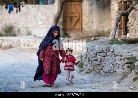 Femme musulmane avec enfant dans des vêtements colorés de village de montagne Banque D'Images