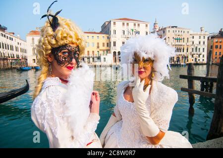 VENISE, ITALIE - 28 FÉVRIER 2020 : deux dames blanches avec un masque posent devant un canal de Venise. Banque D'Images