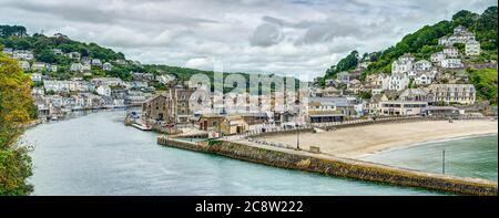 Vue panoramique panoramique et colorée sur la rivière Looe en direction des maisons de West Looe et de la plage de sable et de la jolie ville d'East Looe Cornwall. Banque D'Images