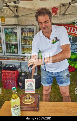 Un homme servant du cidre Somerset au Royal Bath and West Show, un spectacle agricole annuel, près de Shepton Mallet, Somerset, Grande-Bretagne. Banque D'Images