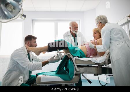 Femme accouchant à l'hôpital avec une équipe médicale Banque D'Images