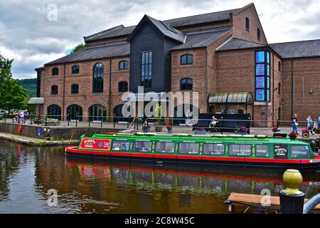 Vue sur la rue Theatr Bryncheiniog, situé sur le côté du bassin central du canal dans le centre-ville de Brecon. Bateau de croisière sur le canal aux amarres Banque D'Images