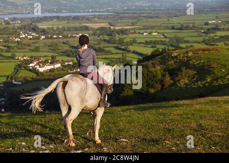Un cavalier sur Crook Peak, dans les collines de Mendip, avec une vue sur les niveaux de Somerset au-delà, Somerset, Grande-Bretagne. Banque D'Images