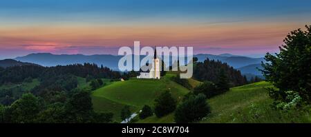 Sveti Andrej, Slovénie - vue panoramique de l'église Saint Andrew (SV. Andrej) au coucher du soleil dans la région de Skofja Loka avec les Alpes juliennes et le ciel coloré au backgro Banque D'Images