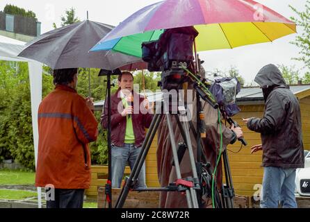 Amstetten, Autriche - avril 29 2008: TV News reporter modérateur dans la pluie battante sur le cas Fritzl Cellar. Banque D'Images