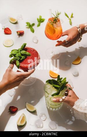 Cocktails d'alcool d'été popllaires dans les mains des femmes sur fond blanc Banque D'Images
