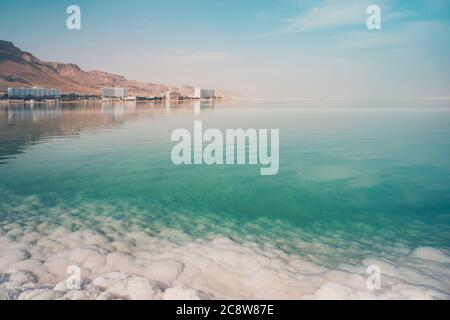 Vue sur la côte et les hôtels spa de la Mer Morte, Ein Bokek, Israël. Formations de sel au premier plan. Voyage Israël. Grands cristaux de sel. Banque D'Images