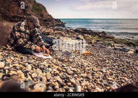 Cuisiner dans la nature. Thé du matin sur la plage. Banque D'Images