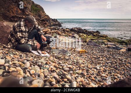Cuisiner dans la nature. Thé du matin sur la plage. Banque D'Images
