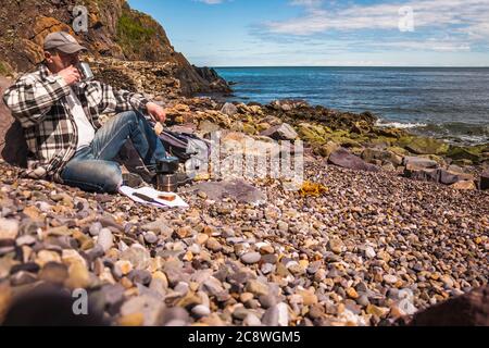 Cuisiner dans la nature. Thé du matin sur la plage. Banque D'Images