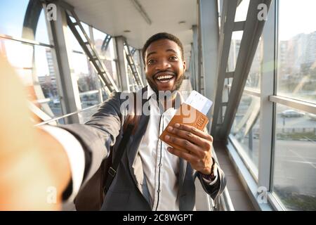 Homme d'affaires Traveler Making Selfie avec passeport et billets à l'aéroport Banque D'Images