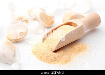 Ajouter de la saveur aux aliments et remède naturel pour le froid et la grippe concept avec gousses d'ail frais et la poudre dans la pelle en bois isolée sur fond blanc Banque D'Images