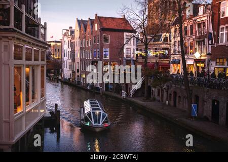 UTRECHT, PAYS-BAS - 25 novembre 2016 : les célèbres canaux et remblais de la ville d'Utrecht au coucher du soleil. Un bateau navigue dans le paysage urbain et le tradi Banque D'Images