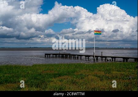 un drapeau arc-en-ciel sur une jetée dans la mer des wadden Banque D'Images