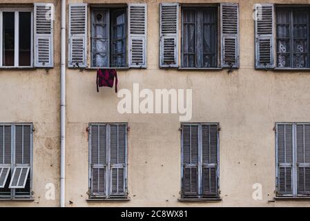 Chemise suspendue à une fenêtre sur une ancienne façade française traditionnelle avec des rangées de fenêtres (jalousie) véhicule un style de vie du centre-ville et l'intimité du quartier Banque D'Images