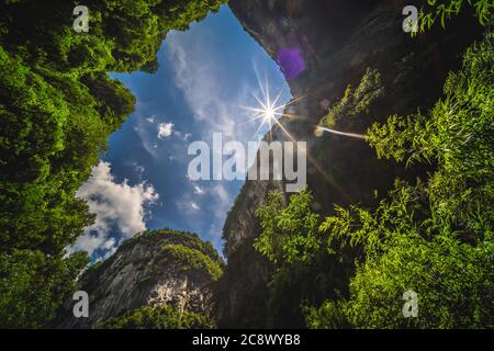 Soleil brillant à travers l'arche rocheuse naturelle et le paysage karstique du parc national de la fissure de Longshuixia, pays de Wulong, Chongqing, Chine Banque D'Images