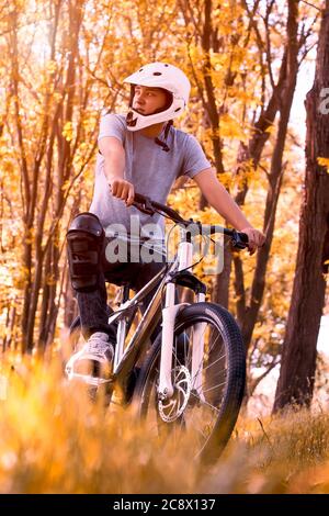 Photo verticale d'un motard de montagne professionnel portant un casque dans le parc Banque D'Images