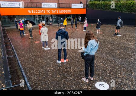 Londres, Royaume-Uni. 27 juillet 2020. Une file d'attente importante se forme et attend patiemment sous la pluie pour les premières heures de la journée - le Tate Modern rouvre aujourd'hui avec les précautions attendues pour les coronavirus, y compris l'entrée chronométrée, la distanciation sociale, les systèmes unidirectionnelle et l'assainisseur. Le « verrouillage » facilité se poursuit pour l'épidémie de coronavirus (Covid 19) à Londres. Crédit : Guy Bell/Alay Live News Banque D'Images