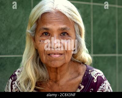 Femme birmane âgée avec de beaux cheveux longs pose pour la caméra. Banque D'Images