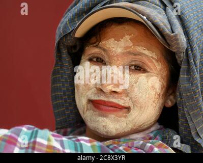 Femme birmane ouvrier de construction avec la protection traditionnelle thanaka visage cosmétique partout son visage pose pour la caméra. Banque D'Images