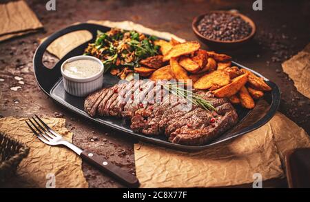 Steak grillé en tranches de Rib Eye avec sauce au poivre et pommes de terre frites dorées Banque D'Images