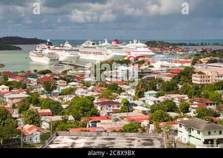 Des bateaux de croisière alignés dans le port semblent éclipser les bâtiments de St Johns, île d'Antigua dans les Caraïbes Banque D'Images