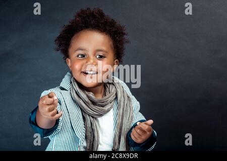 Portrait Studio D Un Petit Garcon Afro Americain Elegant Avec Cheveux En Boucle Isoles Sur Fond Sombre Mode Pour Enfants Vetements Pour Enfants Photo Stock Alamy