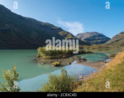 Eaux glaciaires bleu laiteux du lac Bovertunvatnet dans le parc national de Jotunheimen, Norvège. Début de l'automne fond bleu ciel. Banque D'Images