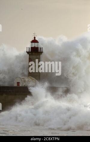 Vieux phare à l'embouchure du Douro pendant la tempête en mer au coucher du soleil. Banque D'Images