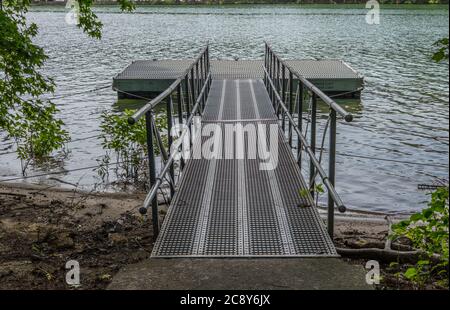 Quai flottant vide utilisé pour les petits bateaux à aubes canoës et kayaks à lancer dans le lac lors d'une journée lumineuse en été Banque D'Images