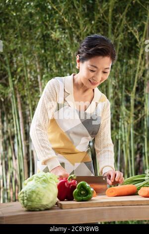 La cour hacher des légumes chez les femmes de la vie moyenne Banque D'Images
