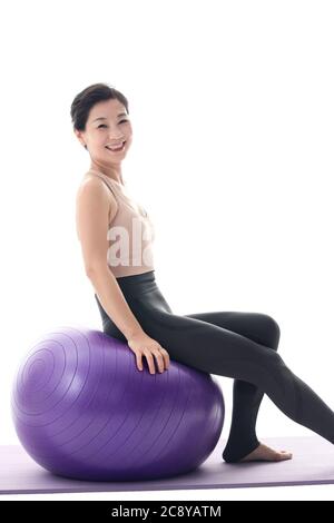 Des femmes d'âge moyen heureuses assises sur une balle de yoga Banque D'Images
