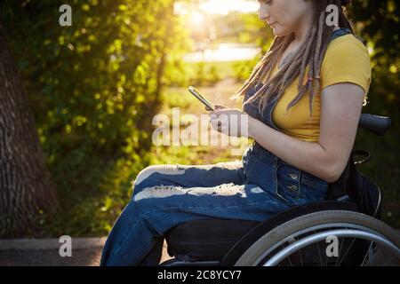 Sérieuse fille lisant e-livre, nouvelles, information du Net dans le parc. Femme à la recherche d'un emploi . gros plan vue de côté photo. Concentration, affaires Banque D'Images