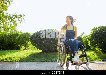 magnifique fille positive en fauteuil roulant se réjouir à la nouvelle journée, pleine photo. sentiment positif et émotion. espace de copie. amour de la vie, gaieté Banque D'Images