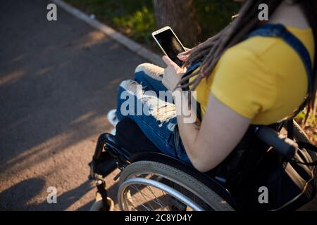 jeune femme utilisant son smartphone à l'extérieur. vue du dessus photo rognée. travail, profession, profession, femme gagnant de l'argent sur le net Banque D'Images