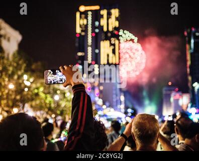 Personnes prenant des photos de feux d'artifice avec leur téléphone, Ho Chi Minh ville, Vietnam Banque D'Images