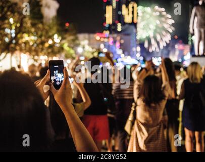 Personnes prenant des photos de feux d'artifice avec leur téléphone, Ho Chi Minh ville, Vietnam Banque D'Images