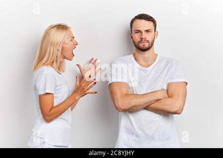 Des femmes frustrées en colère criant à l'homme qui se tient avec des armes croisées, casser ou divorce, concept de malentendu de famille Banque D'Images