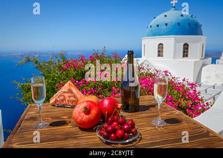 Vin et fruits pour deux sur le fond de la mer et de l'île de Santorini. Banque D'Images