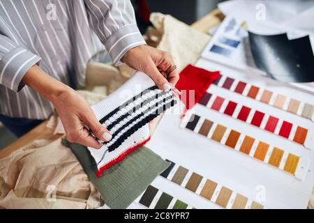 femme choisissant une couleur de tissu dans un magasin. gros plan rogné photo. affaires. vêtement. artisanat concept Banque D'Images