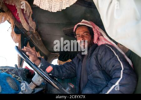 Un jeune bédouin et chauffeur de camion assis dans son camion près de la ville d'Azraq, dans la région de Badia, dans le désert oriental de Jordanie. Banque D'Images