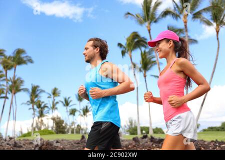 Couple heureux courir ensemble entraînement le matin été vivre un style de vie sain. Des personnes interraciales s'y sont sorties dans le parc d'été Banque D'Images