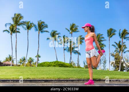 Coureur femme étirant la jambe faisant l'exercice d'échauffement. Jambes étire des exercices avant de courir dans le parc de la ville d'été. Un mode de vie sain Banque D'Images