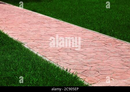 Le trottoir le disposé par une tuile de pierre et pelouse verte, personne. Banque D'Images