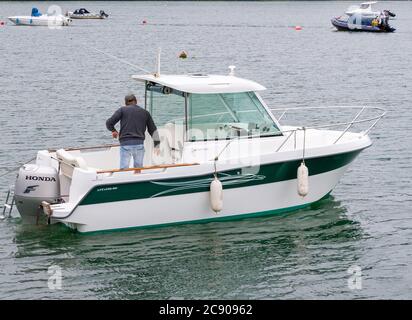 Homme 30-50 à bord d'un bateau à moteur Beneteau Antares 600. Banque D'Images