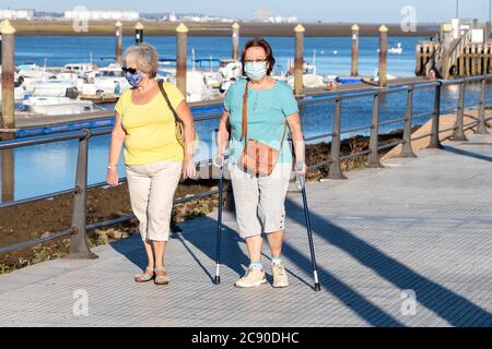 Punta Umbria, Huelva, Espagne - 10 juillet 2020 : deux femmes âgées marchant dans la rue portant un masque de protection en raison de Covid-19. Nouvelle norme en Espagne Banque D'Images