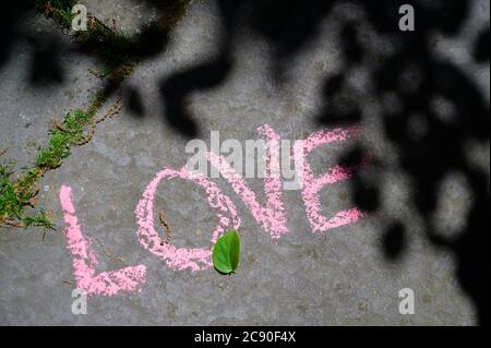 Mot amour écrit dans la craie sur la rue de la ville Banque D'Images