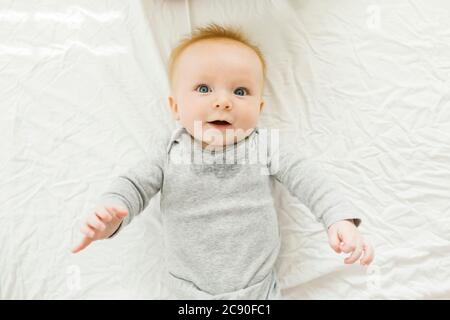 Portrait of baby boy lying on bed Banque D'Images