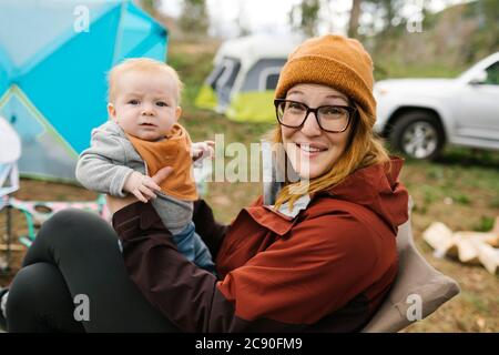 USA, Utah, Uninta Wasatch cache National Forest, mère Holding son (6-11 mois) en camping Banque D'Images