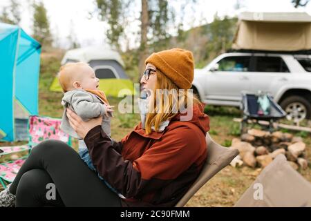 USA, Utah, Uninta Wasatch cache National Forest, mère Holding son (6-11 mois) en camping Banque D'Images